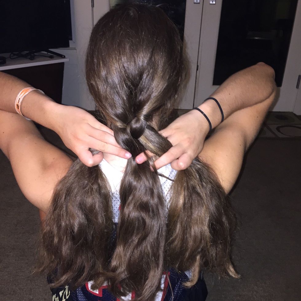 Take the strand on the left, and cross it over the top of the strand that is in the middle.