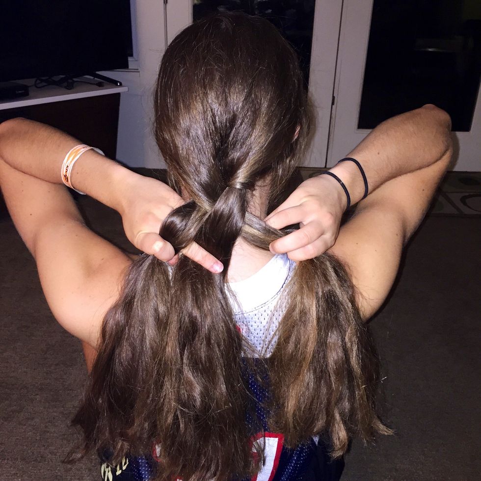 Take the strand on the right, and cross it over the top of the strand that is in the middle.