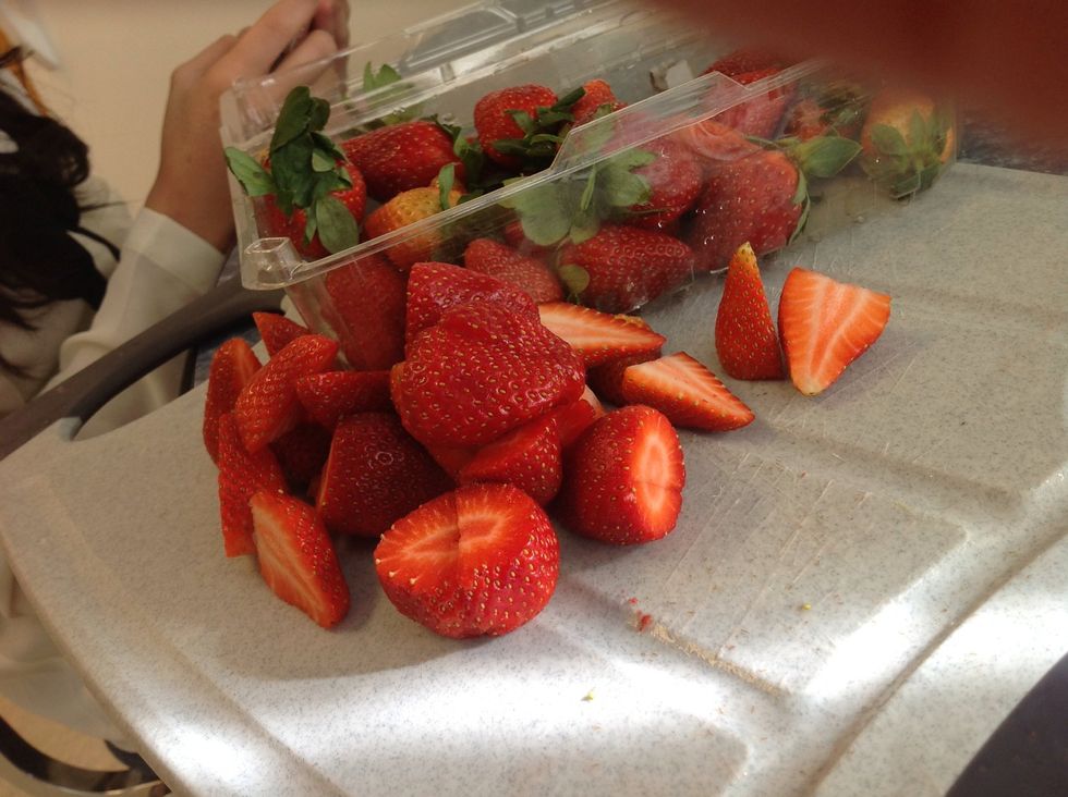 take the strawberries or another fruit you would use to put on your pancakes and wash them first and cut the tips and cut them inhalf.