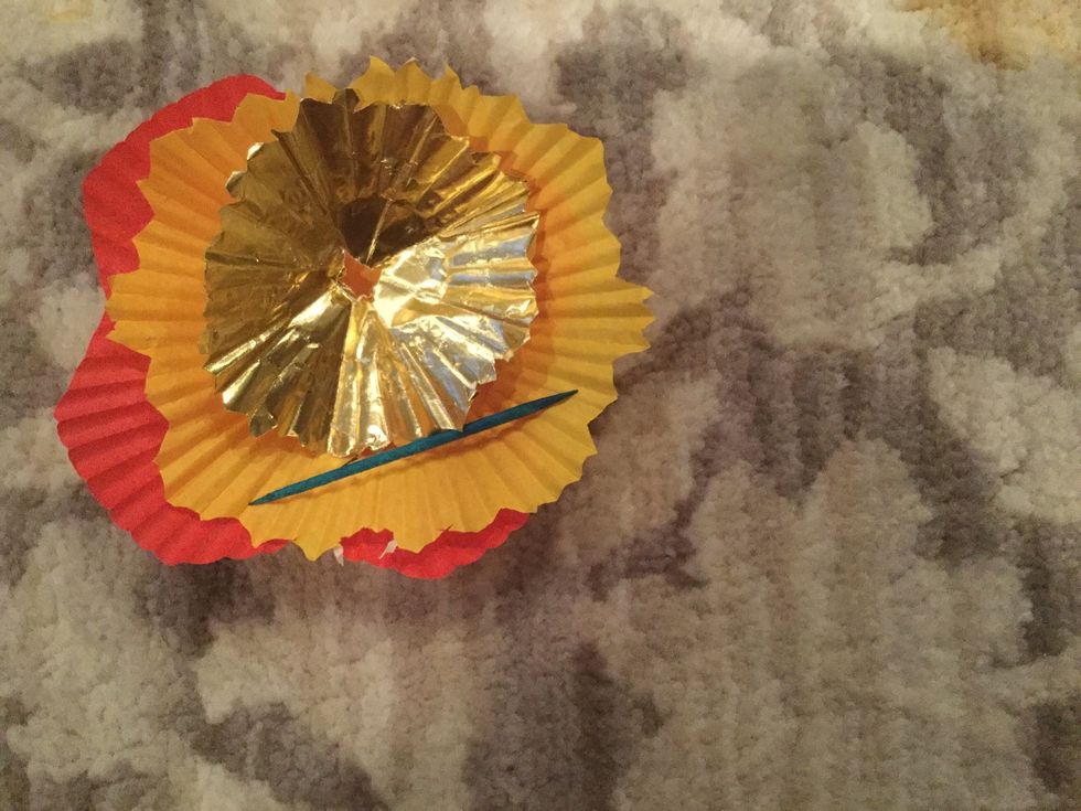 Take the toothpick and cut a small X in the middle of each of your folded cupcake liners.