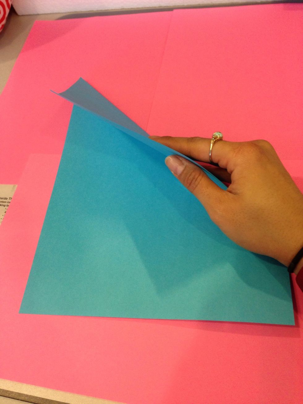 Take the top right and fold it over to the left making a shape of a triangle.