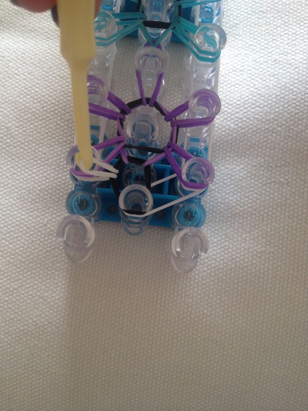 Take the top (white) band a pull it through the peg and around like so.