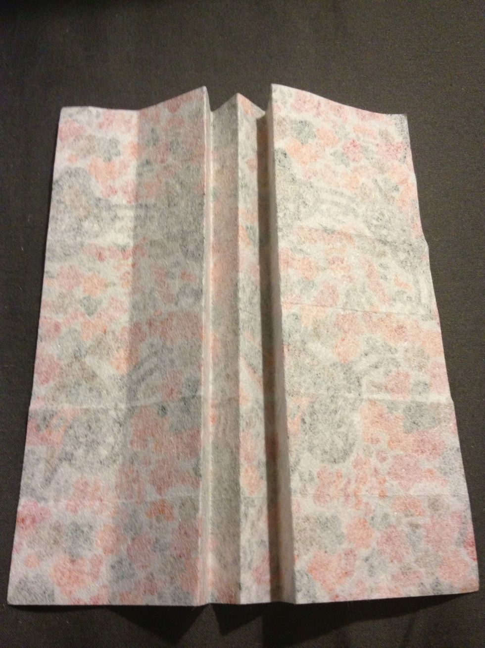 Take the two middle rows and fold them in so they meet the line  in the middle. You will need to fold the square grid in half to do so