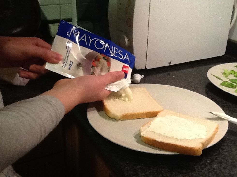 Take the two slices and put some mayonnaise on it.
