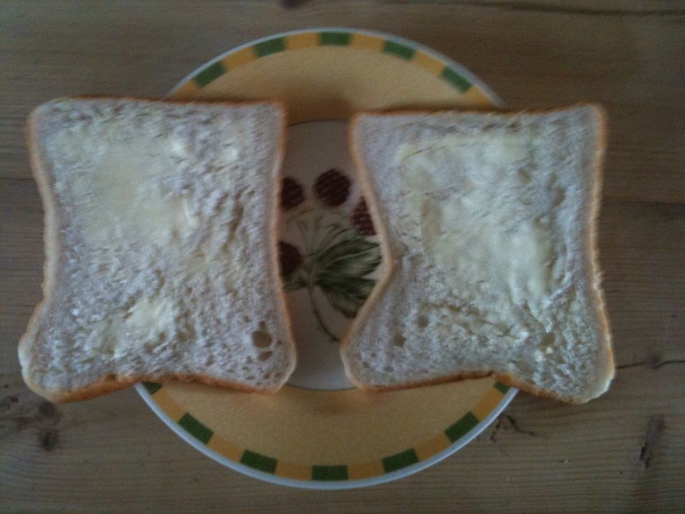 Take the two slices of bread and butter them