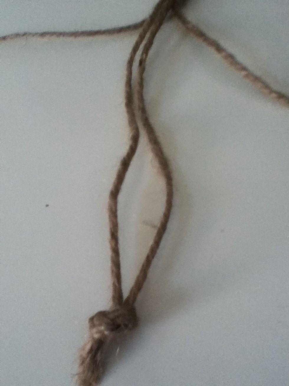 Take the two smaller strings and tie them together just like you did to the top.