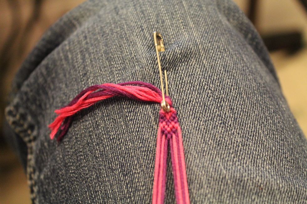 Take the two strings in the middle and tie them together using either the foreword knot or the backward knot.