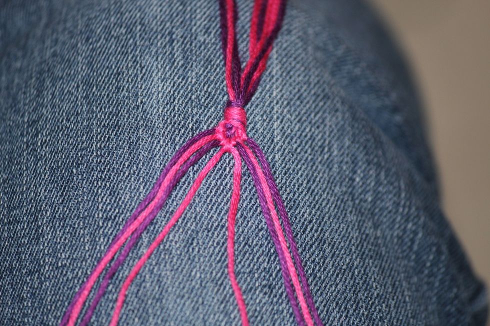 Take the two strings in the middle that you just got done tying knots with and tie them together using either the foreword knot or the backward knot.