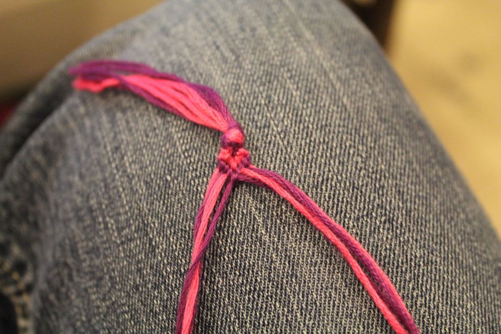 Take the two strings in the middle that you just got done tying knots with and tie them together using either the foreword knot or the backward knot.