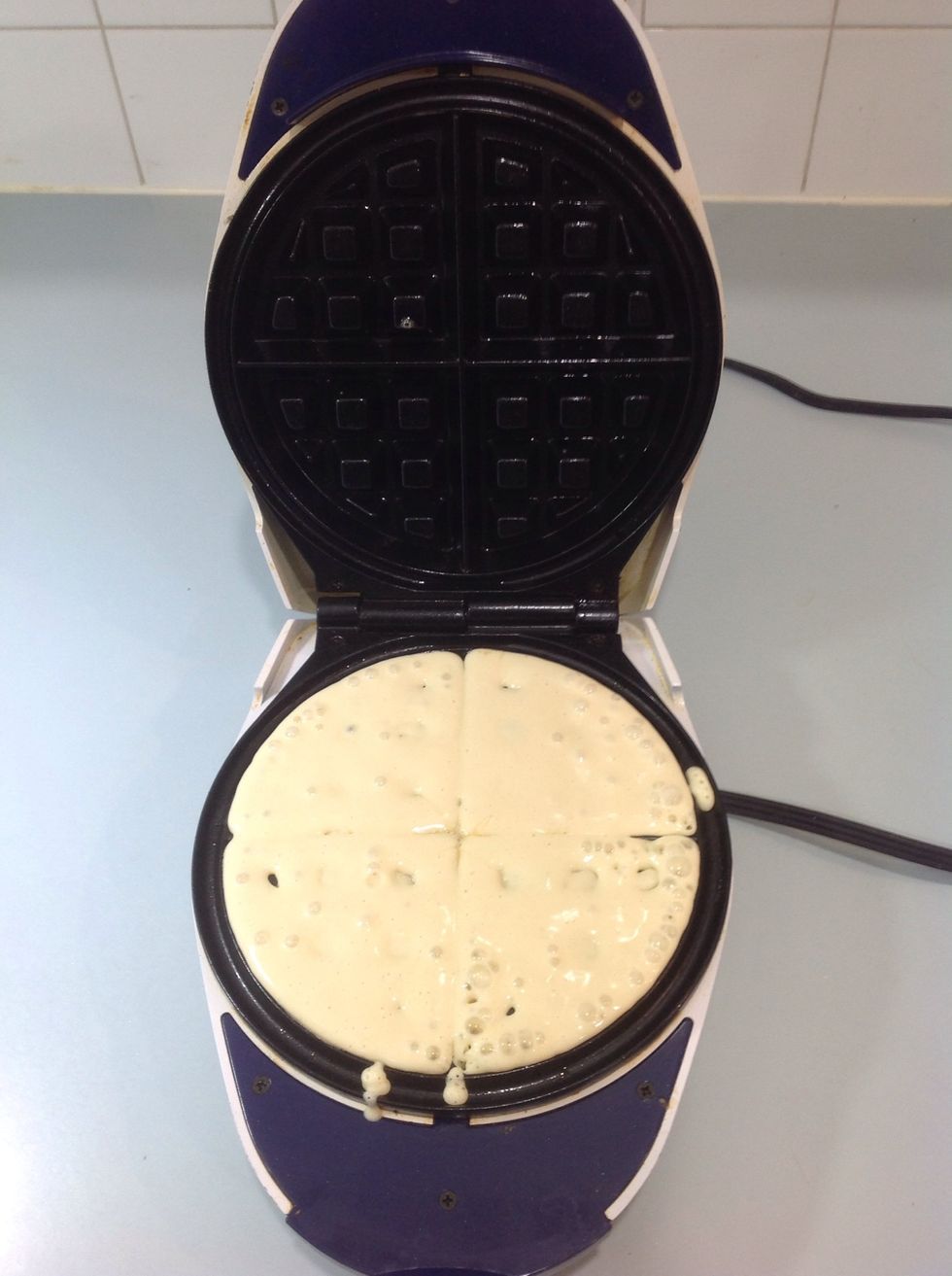 Take the waffle mixture and pour it into the bottom half of the waffle iron until it is filled to the rim.