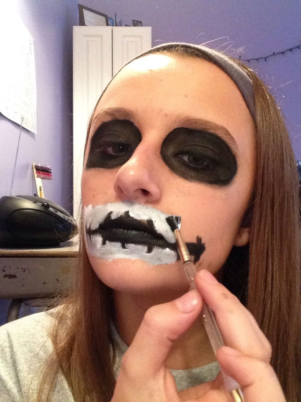 Take the white face grease with a small make up brush and carefully do the detailing around the stitching