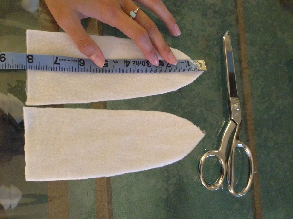 Take the white fleece and fold it <--- this way u can save time and cut two pieces instead of one each. I measured 7 in top to bottom and with just an eye, created my own curve.