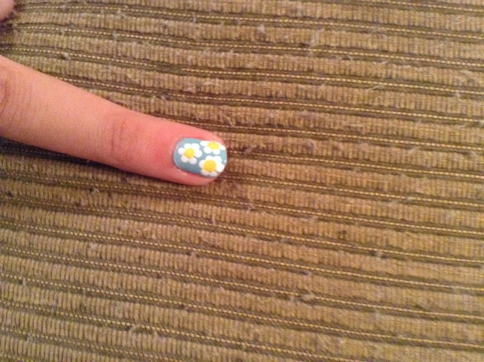 Take the white polish and the next biggest dotting too, and make dots around the yellow ones.