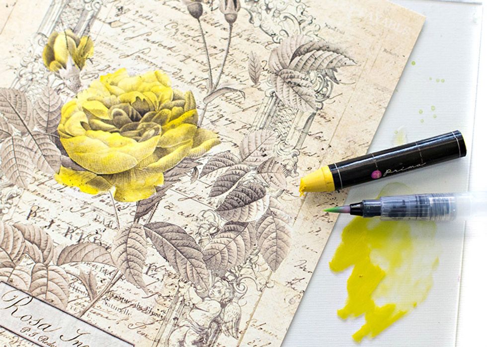 Take the yellow oil pastel and color it on to a smooth surface, like a craft mat. Using the water brush begin to pick up some of the color and apply it to the flowers.