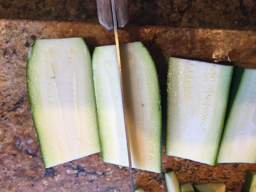 Take the zucchini halves and keep cutting them in half to make spears.