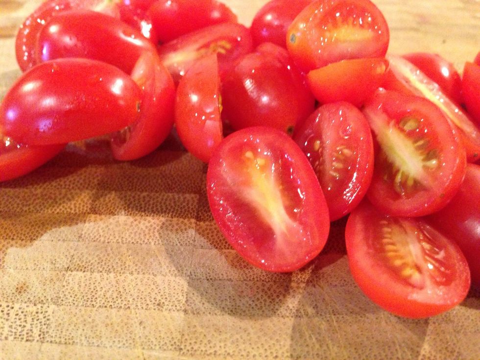 Take those grape tomatoes and slice in half.