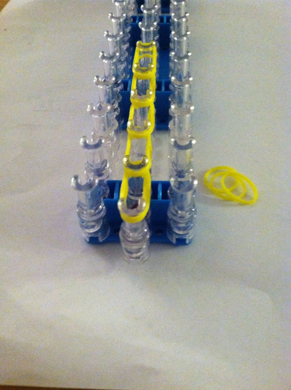 Take three bands at a time and place them on your loom 5 times up your loom so you will be using all fifteen yellow bands