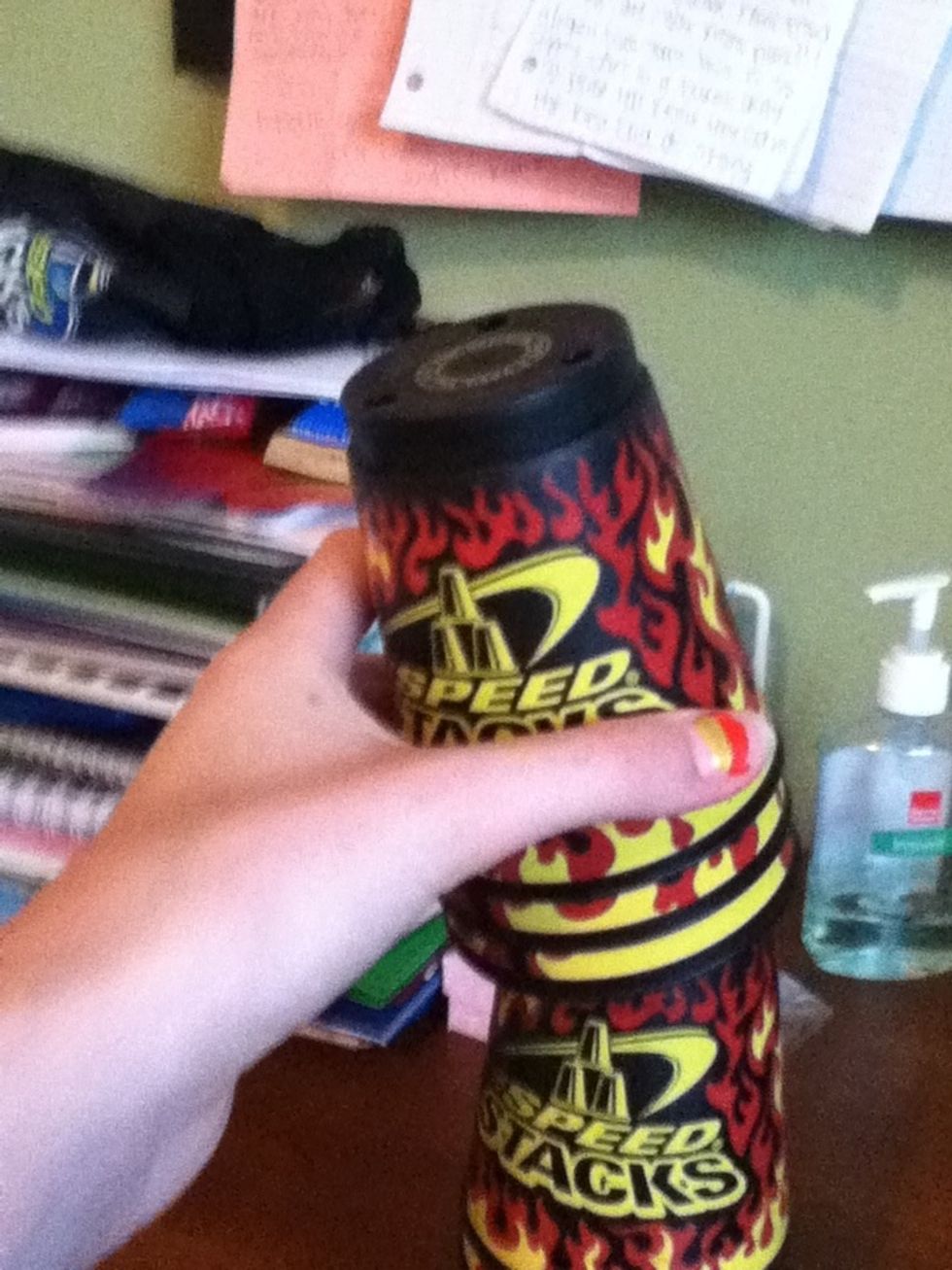 Take three cups off with your left hand and place it on the table on the left side of the main stack.