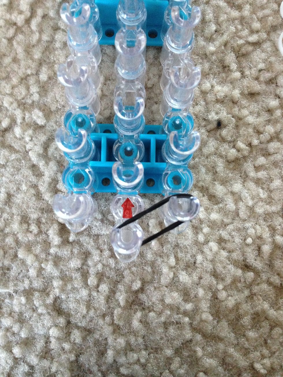 Take two bands of your first color and put it from the middle pin to the outside pin. Make it is TWO rubber bands.