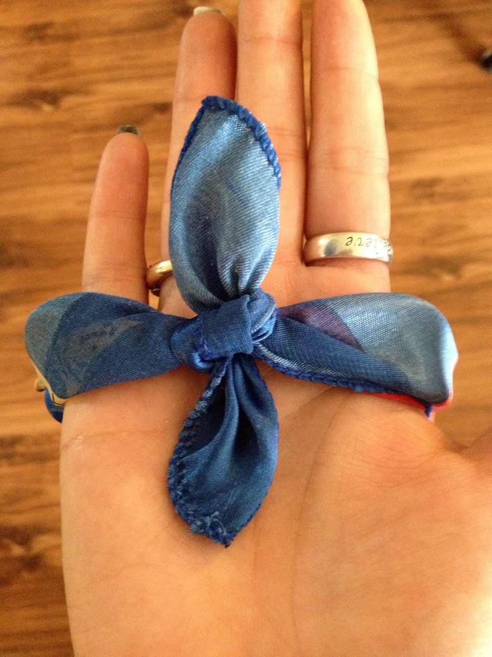 Take two corners and make a nice double knot, do the same to the other two corners.