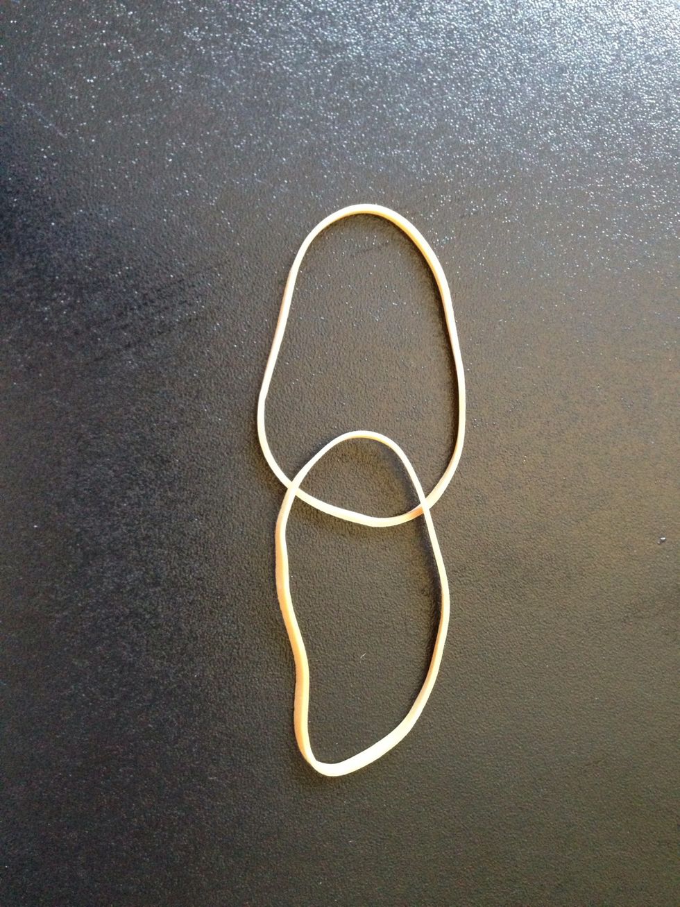 Take two rubber bands and place one of them on top of the other.