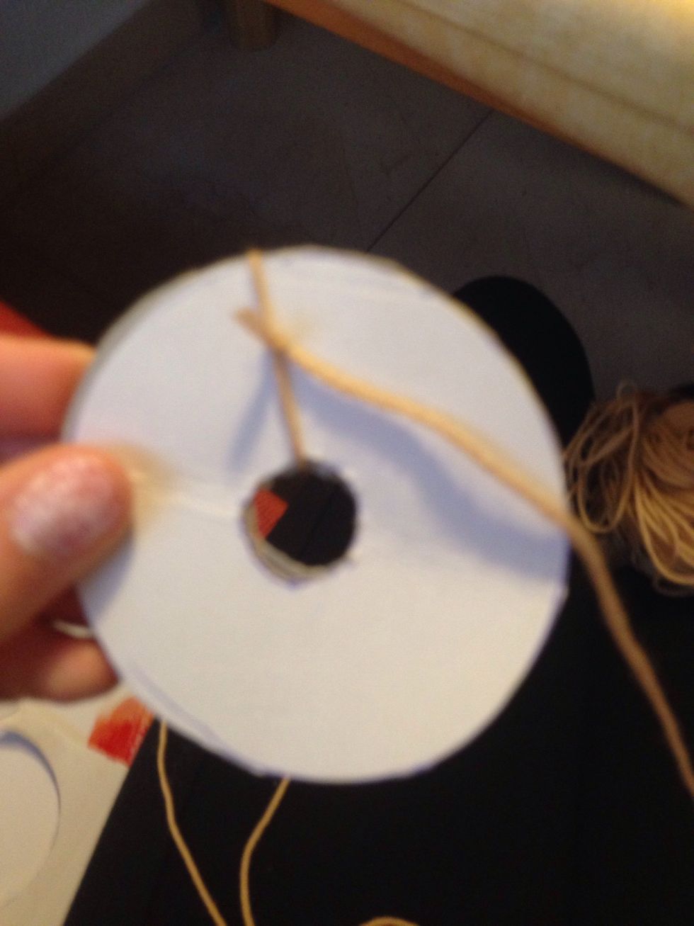 Take wool and take a long piece, cut it off and tie it around the paper