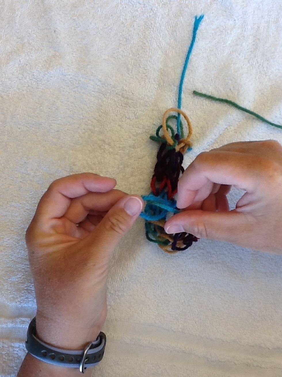 Take yarn and insert through hole.