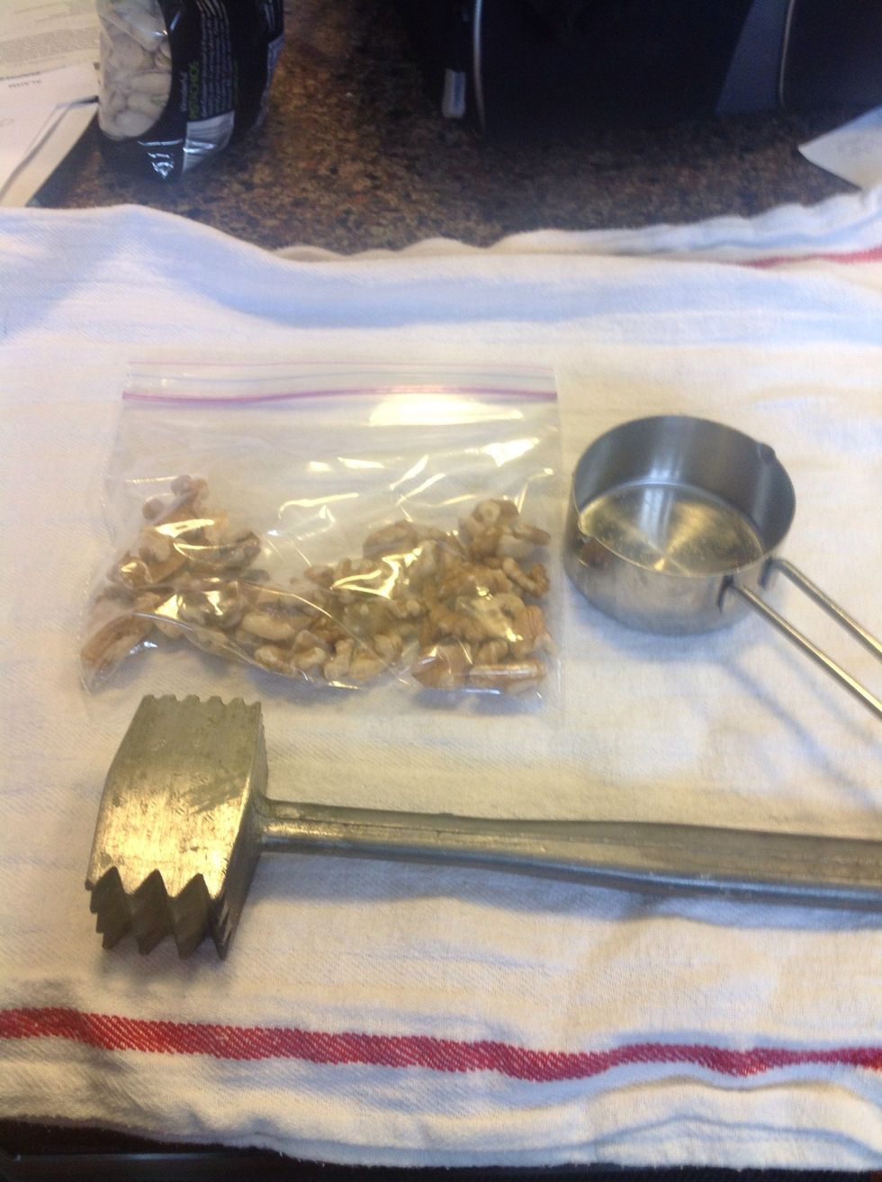 Take your 1/2 cup of nuts and chop them. If you don't have a nut chopper put them in a small Baggie and pound the bag of nuts to crush them gently. I used the side of my meat tenderizer as a crusher