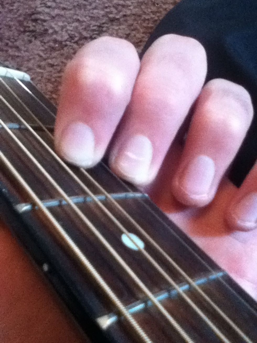 Take your 1st finger and put it two strings above your middle finger on the 3rd string, 2nd fret.