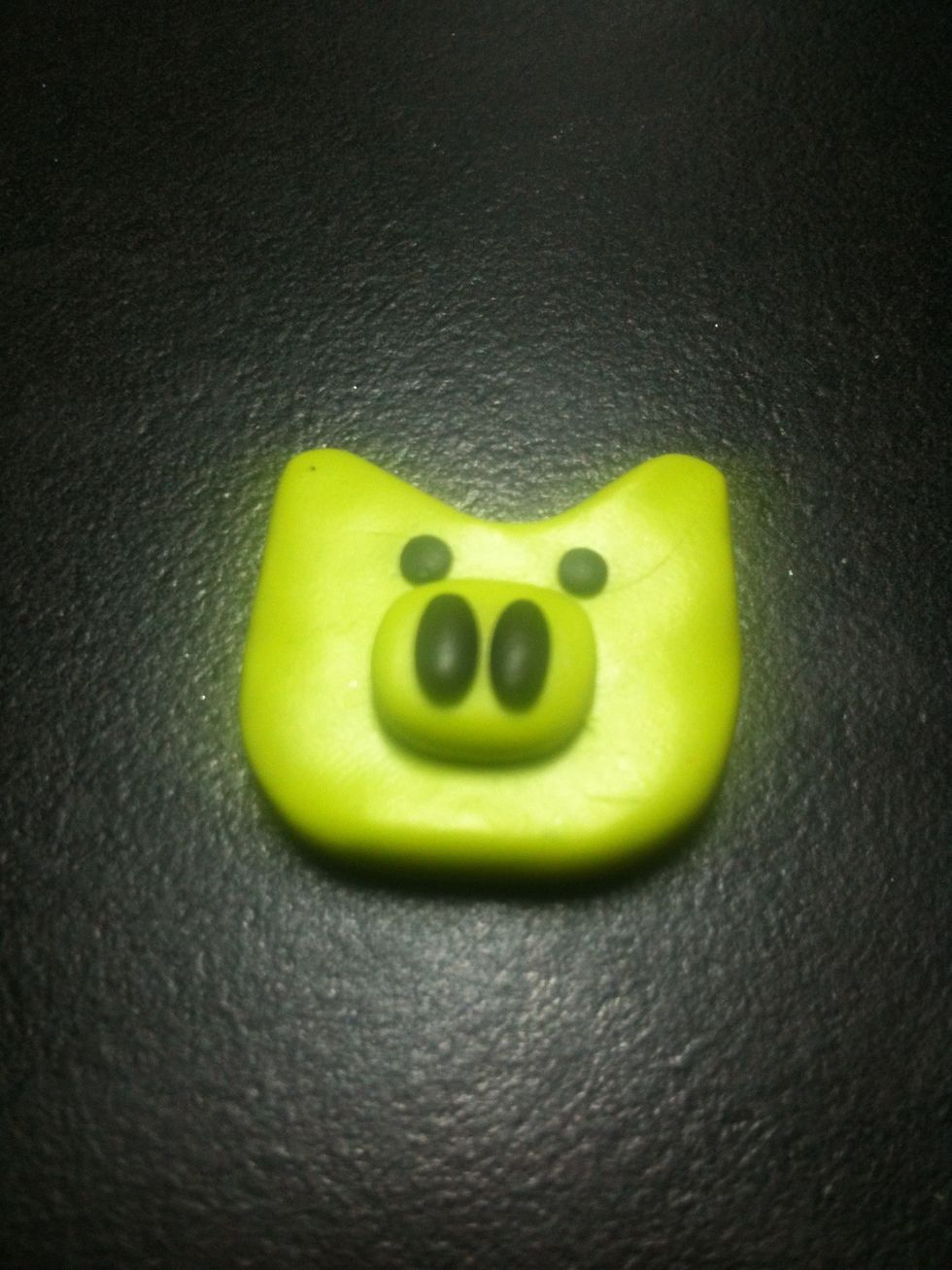 Take your 2 big balls of black clay and roll them out to small logs,and apply them on the nose. Then take your small balls and put them above the nose for the eyes.