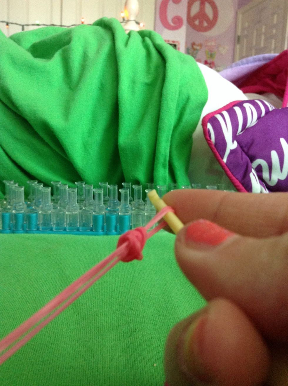 Take your 3 time looped rubber band and pull it off the hook and onto the 2 bands like so