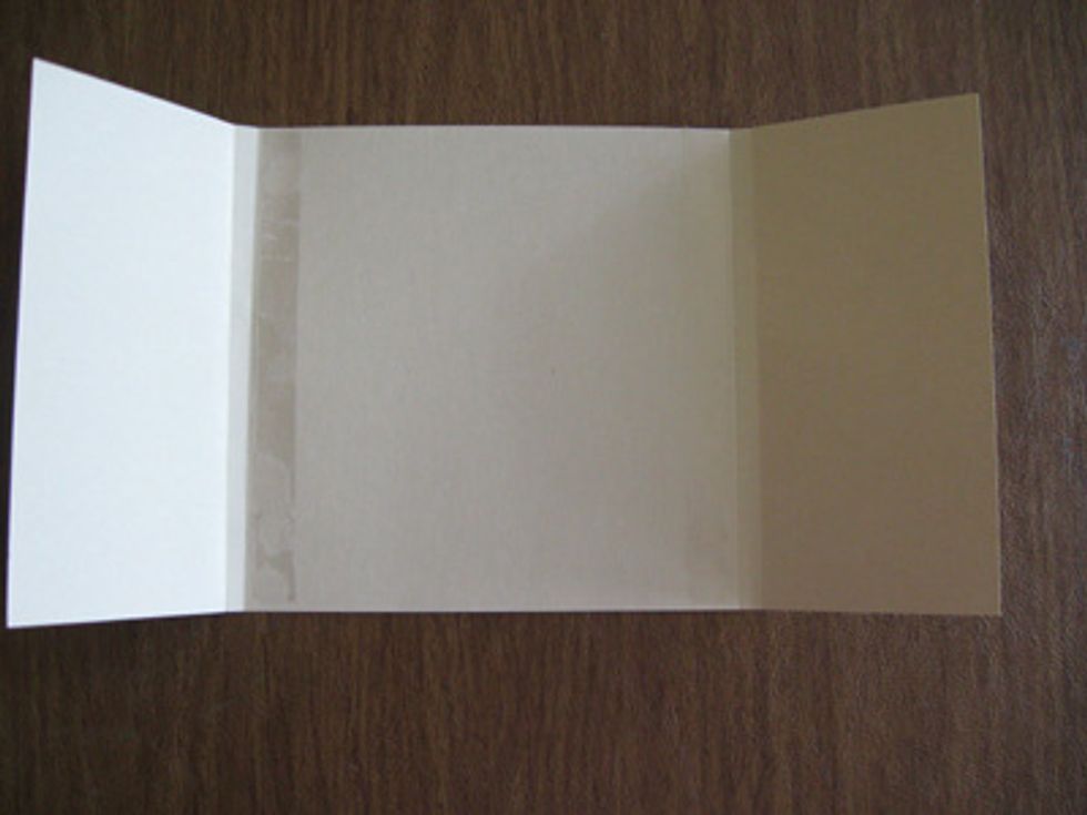 Take your 6 inch by 12 inch cover and put double sided tape just inside the middle score lines.Place the inside of your mini scrapbook onto this double sided tape.