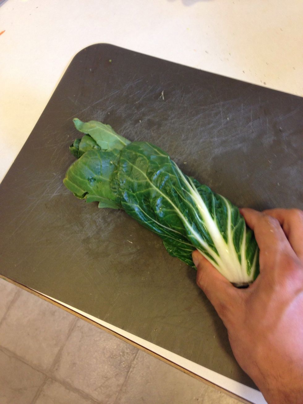 Take your bok choy and slice slice them. You can use the green leafy parts and white ribs. Easy way to slice, layer the leads and roll them together