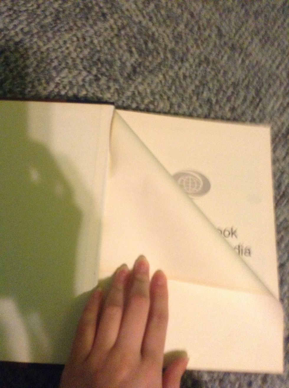 Take your book and begin to fold it like this (top right corner to inside)