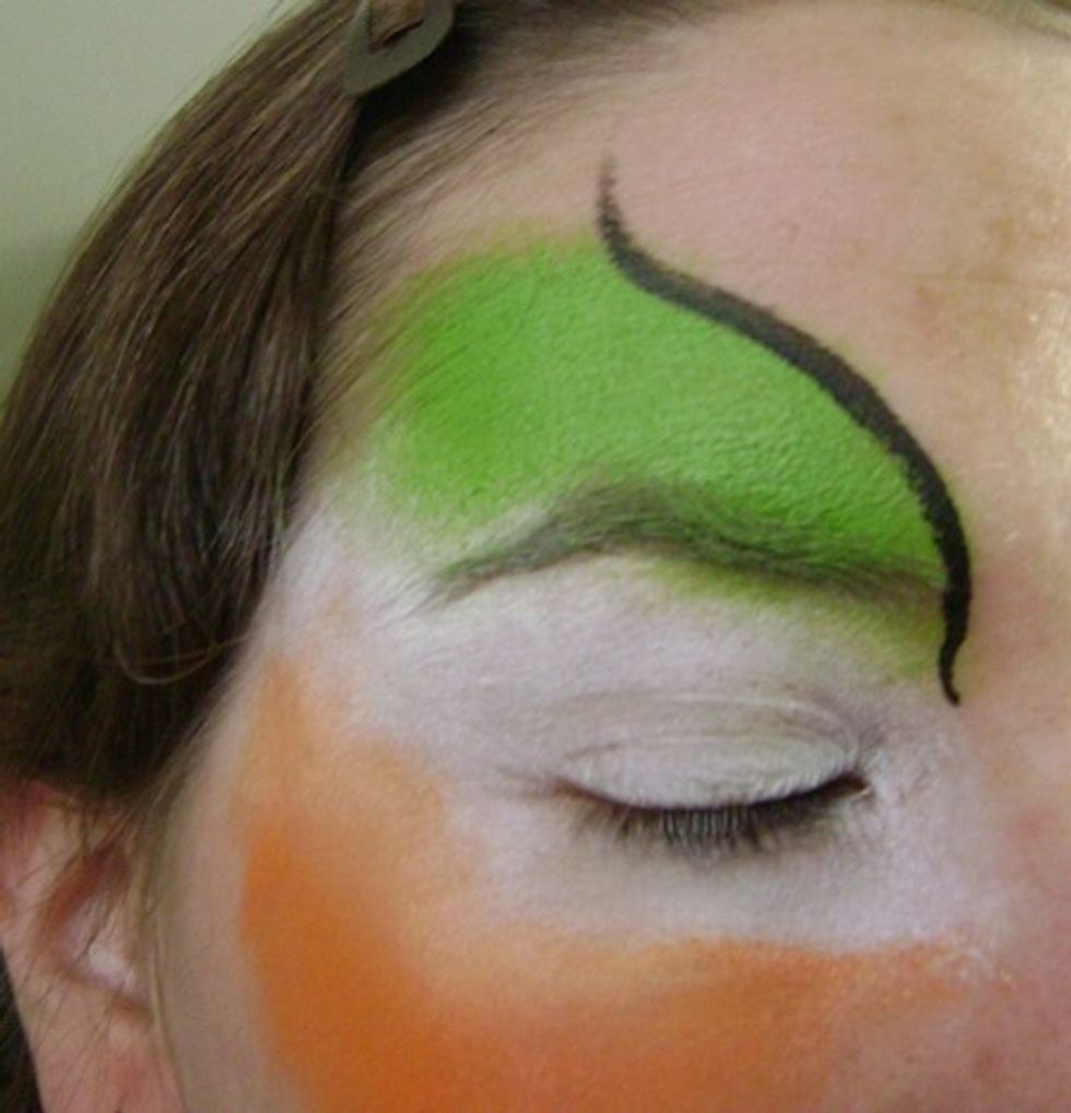 Take your brush and dip it in the black. Trace the outline of the green with a swirl at the end.