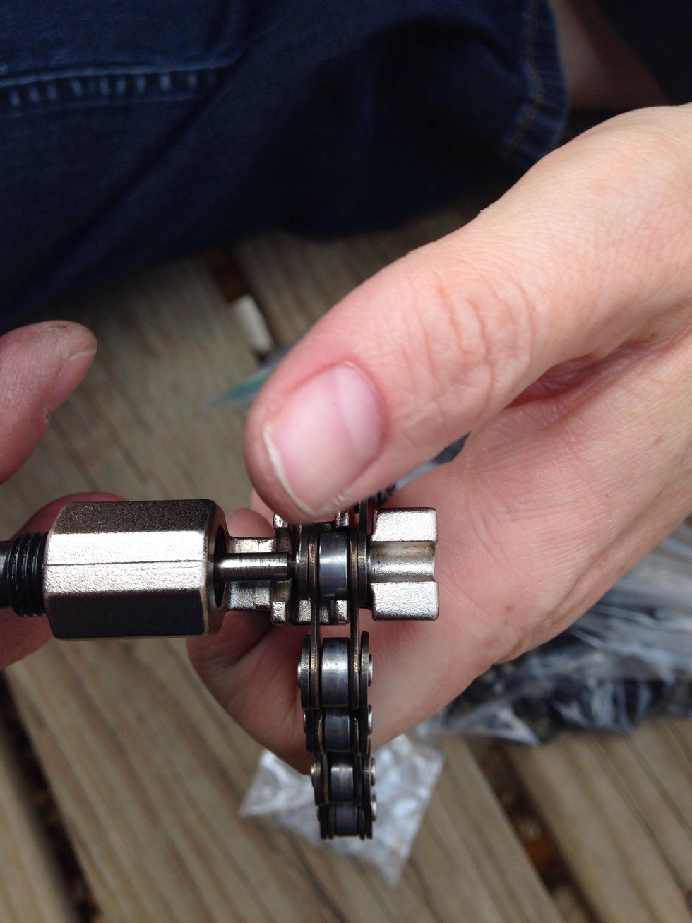 Take your chain tool and set the link in to be removed