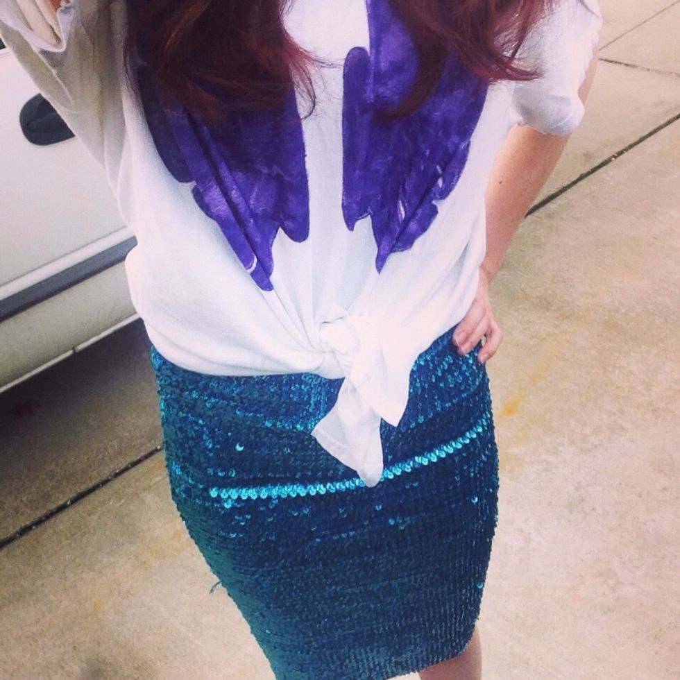 Take your fabric shears and cut a straight line up the middle of the shirt so you can knot it at your waist. Pair the shirt with a sequined skirt and your mermaid outfit is complete!