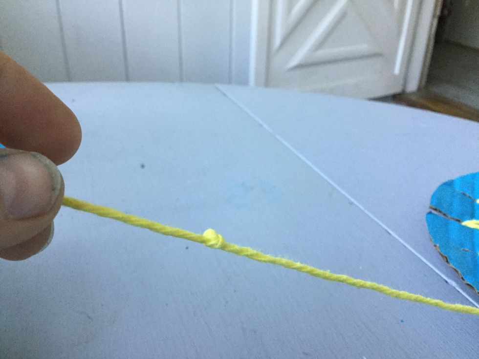 Take your first ball of yarn and make a knot at one end