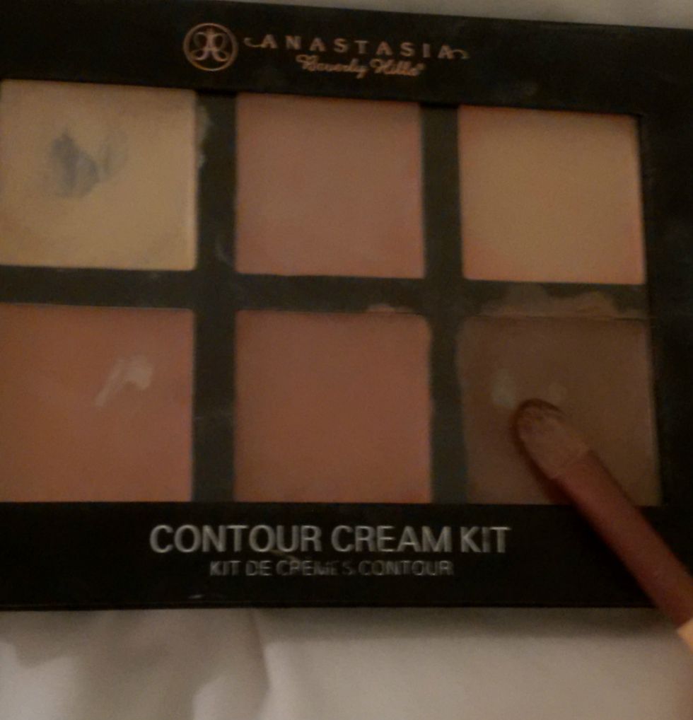 Take your first small flat ended brush (mine is a concealer brush) and take a small amount of your dark colour. I am using shade cinnamon from the Anastasia Beverly Hills cream contour kit.