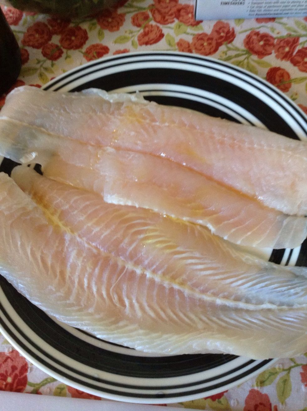 Take your fish fillets - here I'm using catfish which is a personal favorite - and cover with a light coat of olive oil. Go ahead, use your fingers to spread it around. On both sides.