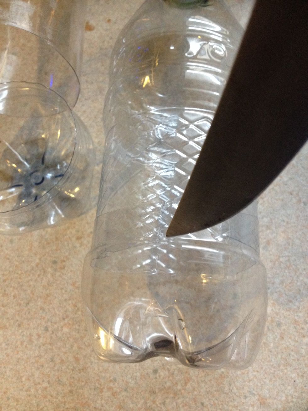 Take your knife and puncture a hole in your water bottles. Then take your scissors and cut around the rim to your desired length. Be careful not to stab yourself!