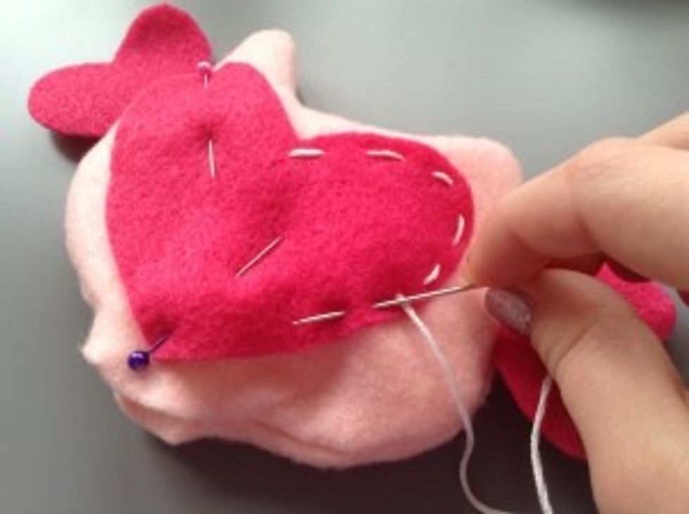 Take your large heart and pin it to the front of your owl.  Stitch it on using as embroidery floss.  You can also hot glue it on if you want, but it would look better with the stitches.