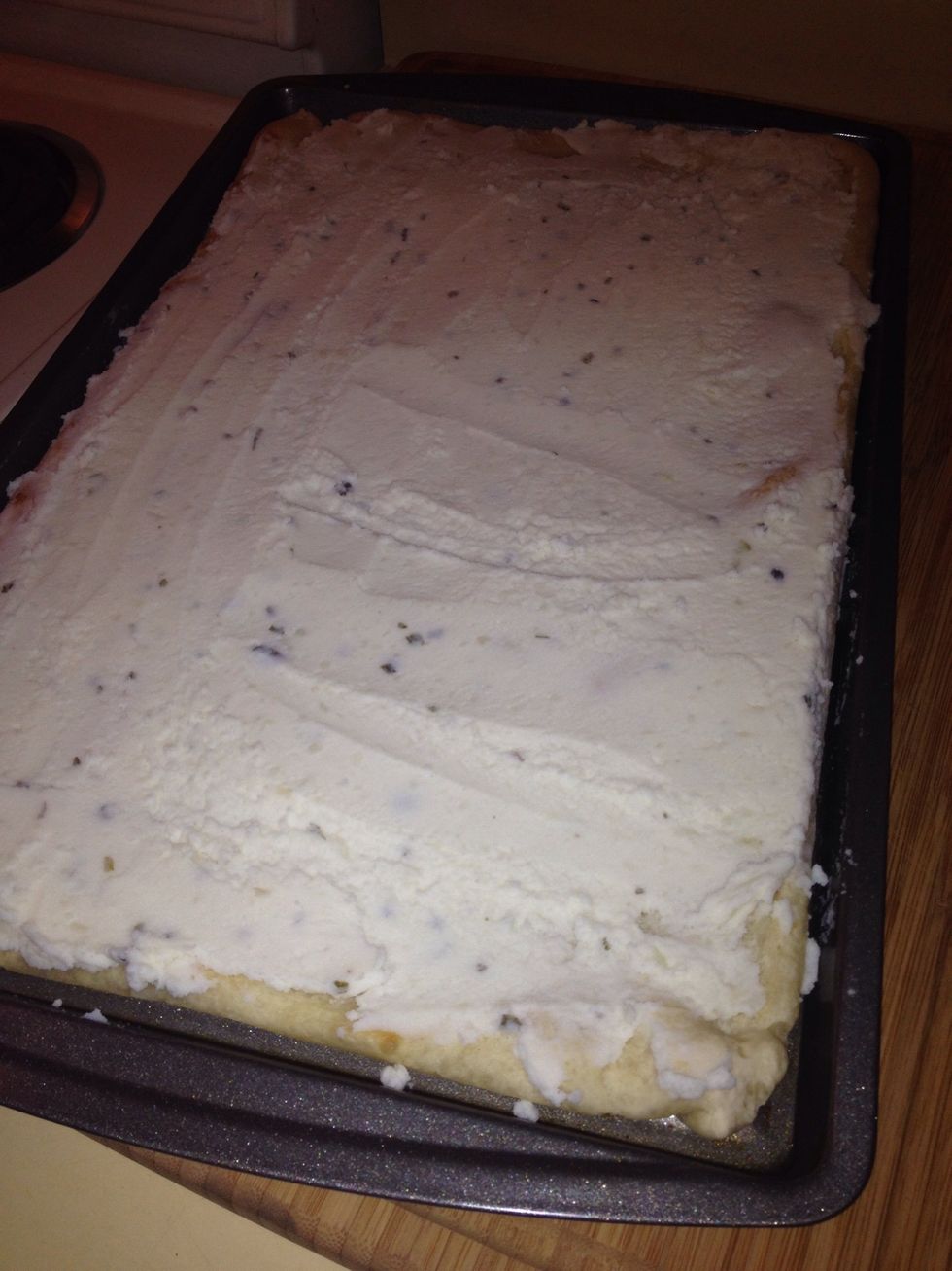 Take your mashed potatoes and evenly spread a layer over the dough. Once you've spread all the potatoes, drizzle garlic butter evenly over the potatoes.