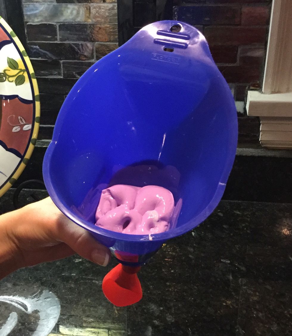 Take your mixture and put in the funnel. Then use the pen to push the mixture inside of the balloon.
