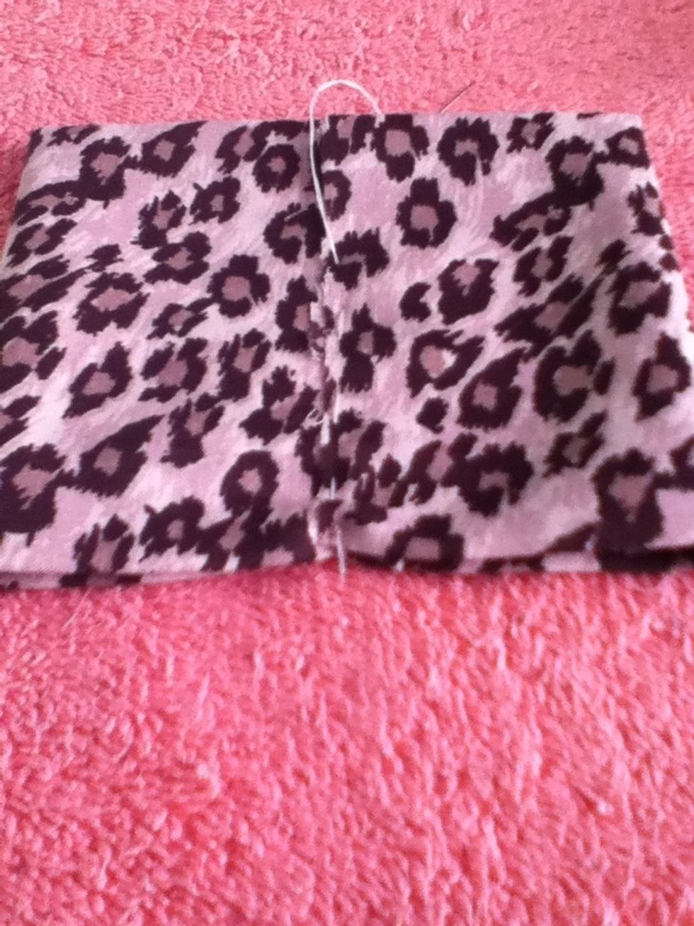 Take your needle and thread and obviously place your thread through the needle and tie a not at the end. Then sew through the middle of the overlapping fabric edges.