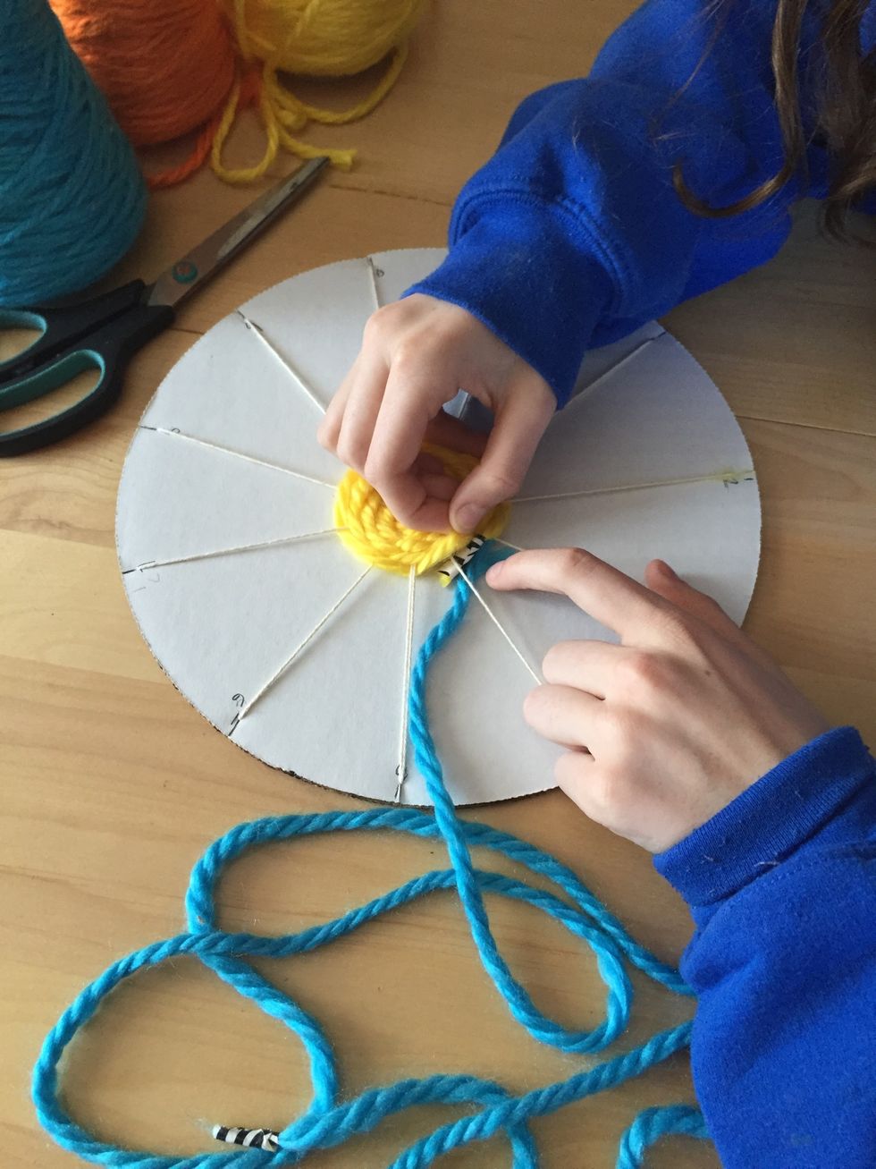 Take your next color of yarn and tuck the non taped end under your weaving, right where you left off with your first color.