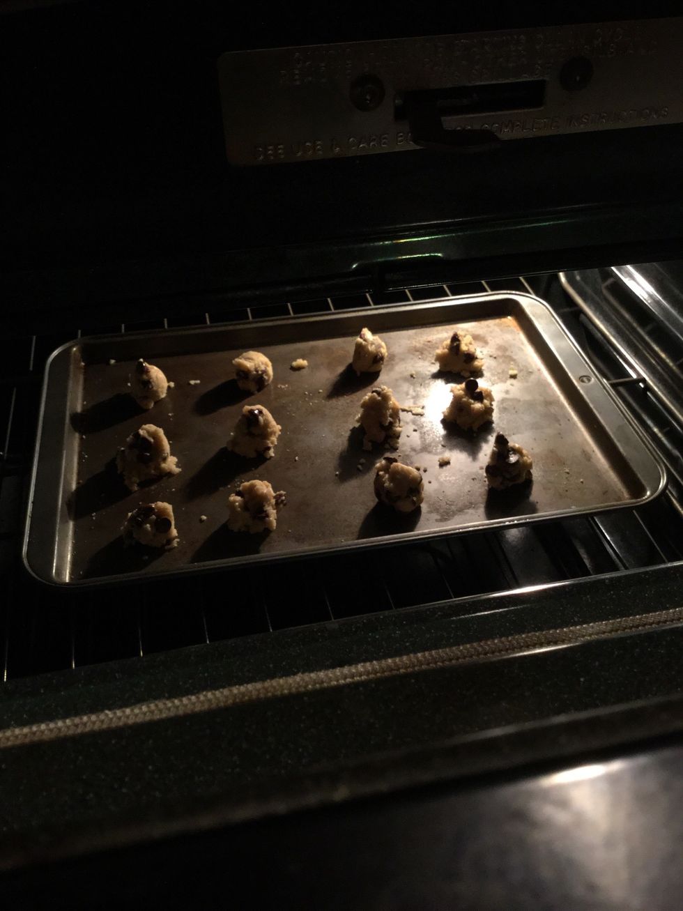 Take your oven mitts and put the cookies inside of the oven.