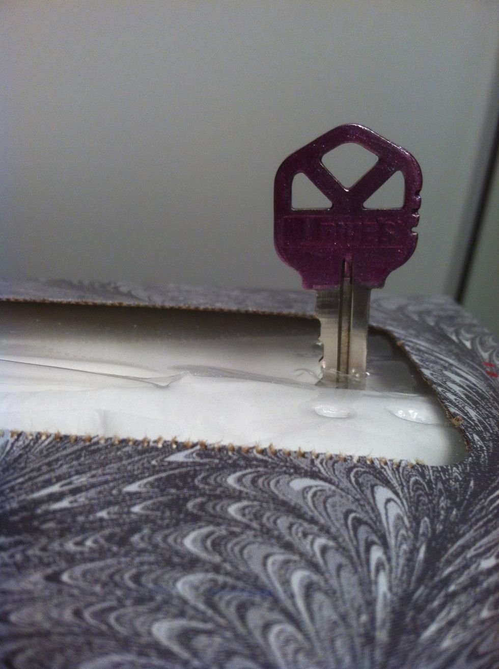 Take your painted key and carefully stick it through the plastic part of your Kleenex box. This way you can dry both sides at the same time. I'm sure there are other things you could use too!