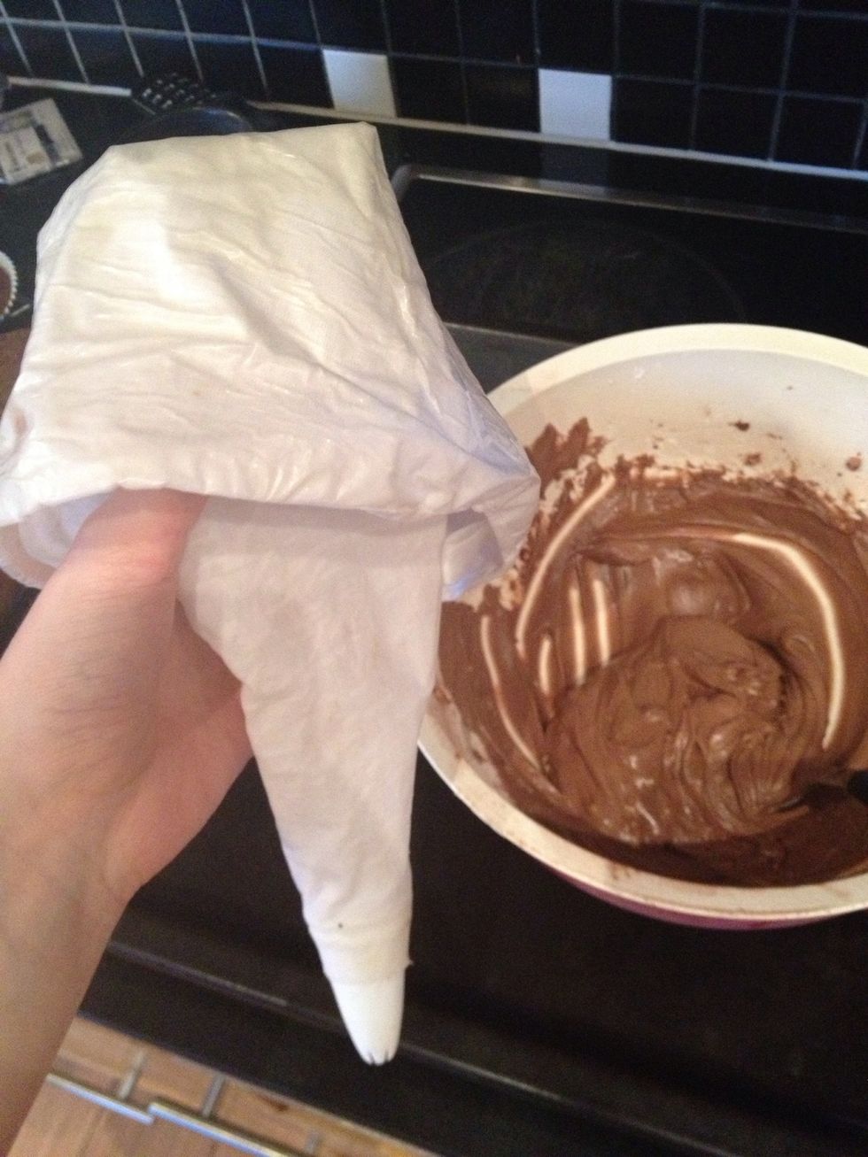 Take your piping bag and fold it down a bit like this, then put in some frosting.
