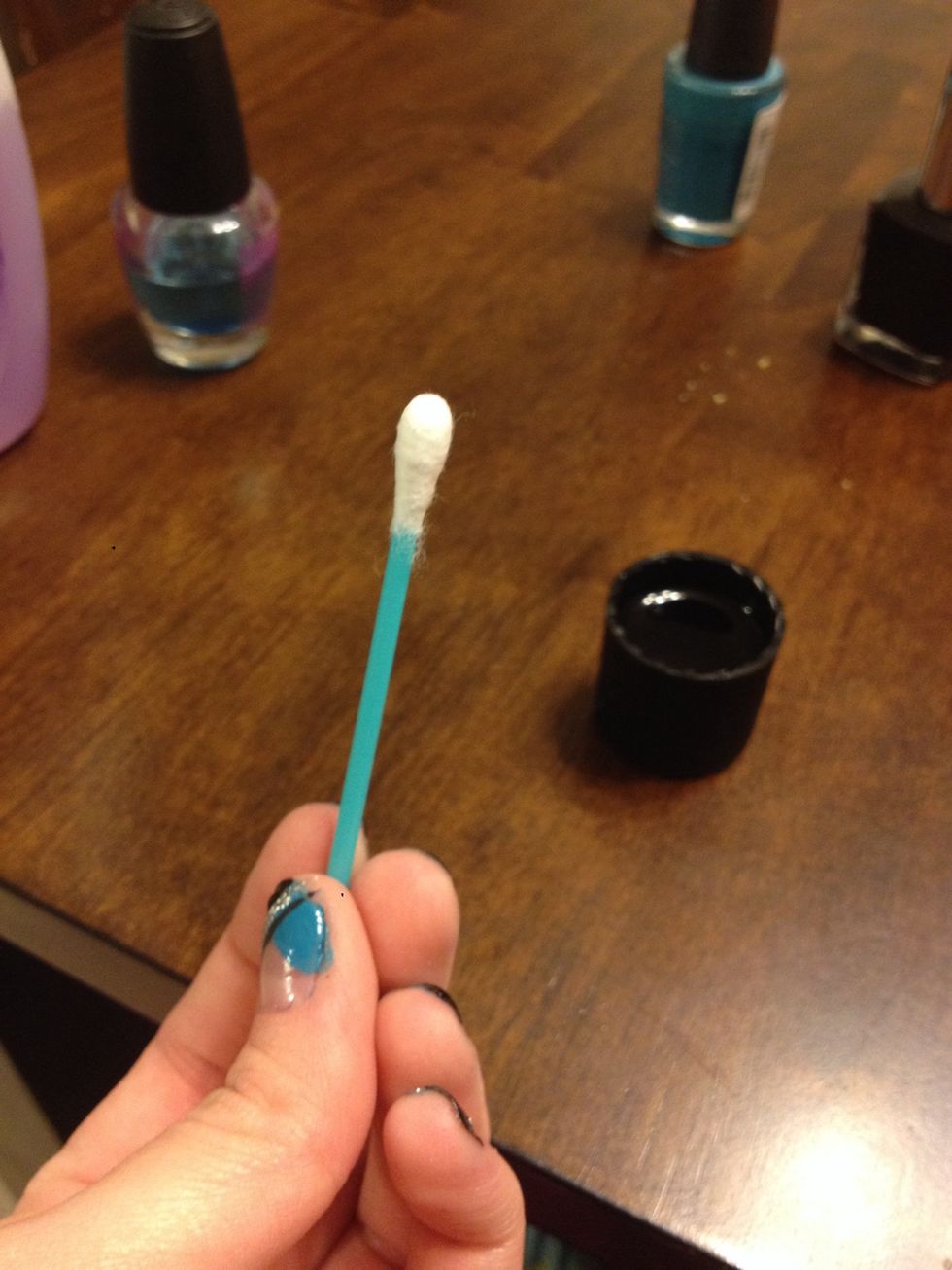 Take your Q-Tip dipped in polish remover and clean up around your nails